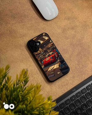 Porsche 911 iPhone case featuring a vintage red racing Porsche with number 95, parked inside a detailed retro garage with warm lighting, workshop tools and automotive memorabilia.