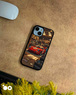 Porsche 911 iPhone case featuring a vintage red racing Porsche with number 95, parked inside a detailed retro garage with warm lighting, workshop tools and automotive memorabilia.